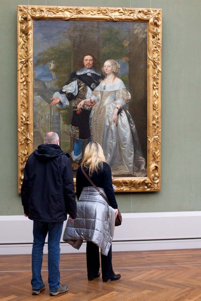 женщина и мужчина перед портретом